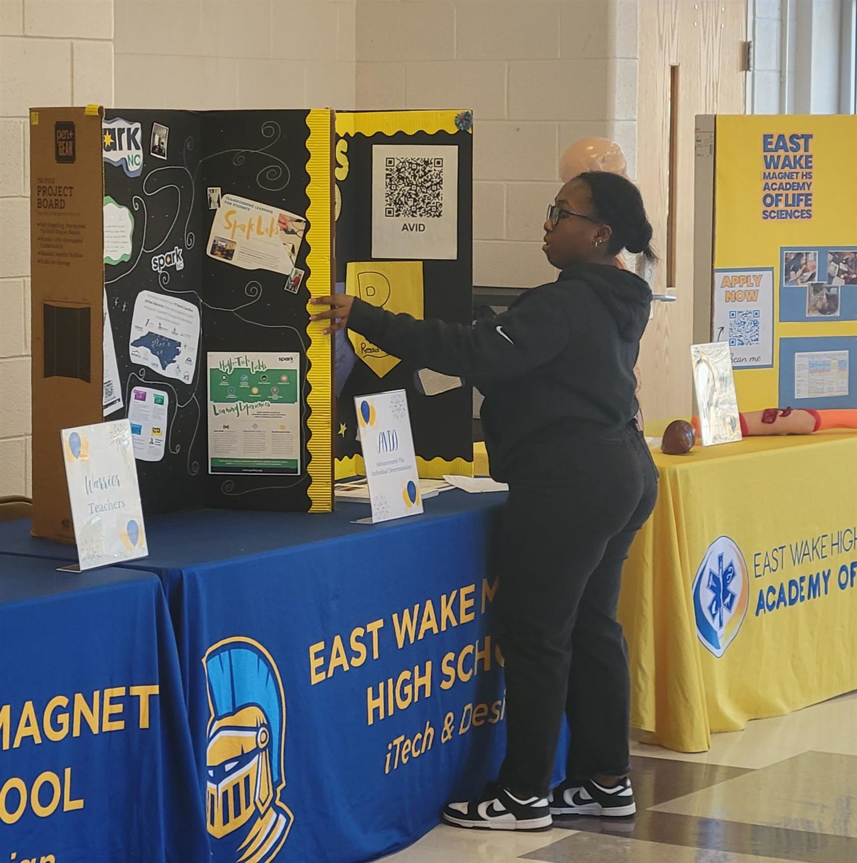 Student adjusts a display a display for the AVID program set on a table. 